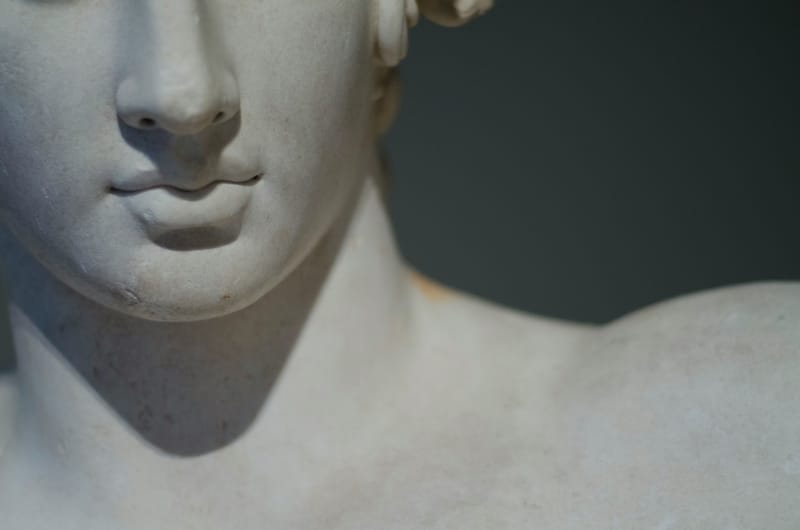 A close-up of a classical marble sculpture — partial reveal of the form already present in the stone.